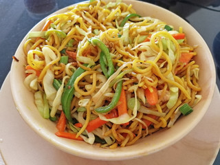 a bowl of noodles with vegetables close-up served in a cafe. delicious dish of Asian cuisine