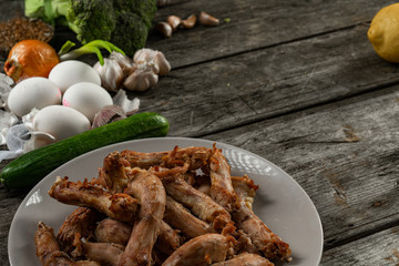 Natural food concept. Plate of fries chicken necks, cucumber, white eggs and vegetables