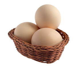 chicken eggs in a basket, isolated on a white background.