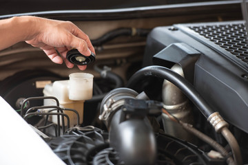 Car maintenance service , hand checking automotive brake fluid system for safety drive.