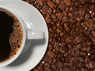 Close up of a cup of coffee on coffee beans background. Top view