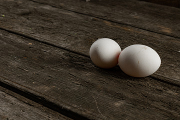 Two chicken white eggs on the wooden background