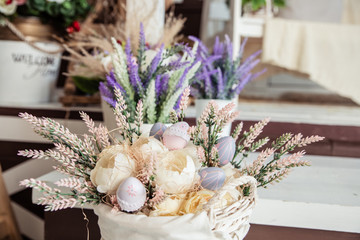 Festive Easter decoration, dry plants, flowers in a basket on wooden table. spring flowers, handmade present for the holiday, Easter Holiday.Easter greeting card