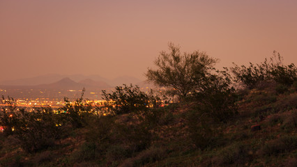 Sweeping views of desert mountains and small neighborhoods under skies that rapidly change vibrant colors as the sun sets in the southwest USA