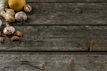 Garlic, lemon, ginger, folk remedies for the common cold in the left corner on a wooden table