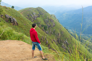 A man enjoying the mountain scenery on the edge of a cliff