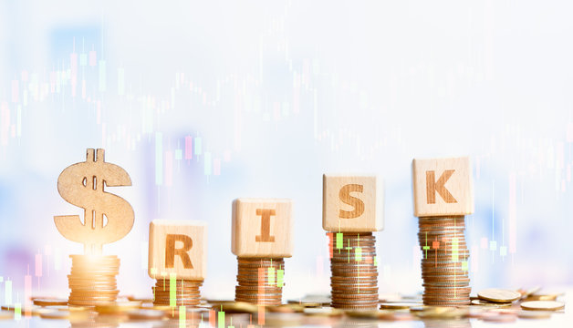 Golden dollar sign on coins stack and word wood block RISK. Financial risk concept. Money management, interest rates.