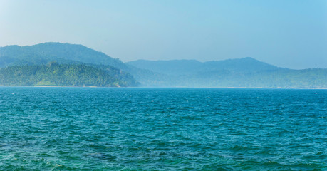 Tree-covered hills by the ocean.