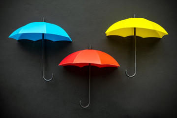 Three colors blue, red and yellow umbrella 3D icons isolated on black background