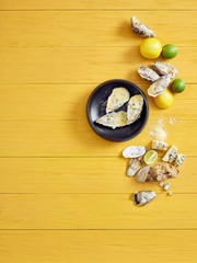 Fresh oysters with a zingy lemon dressing on a yellow woden table