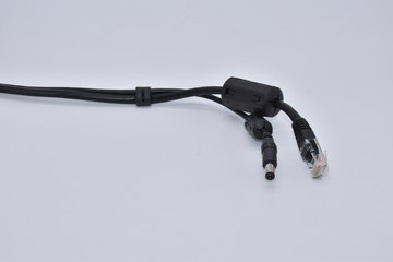Power Over Ethernet PoE cable. Power supply over ethernet cable with two connectors, DC connector attached with ferrite and RJ45 connector isolated on white background.
