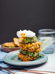 Steaming pea and corn fritters with poached egg