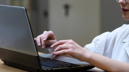 Freelancing and remote work. Young woman with glasses typing a letter on a laptop,
