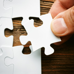 Hand with missing jigsaw puzzle piece. Business concept image for completing the final puzzle piece
