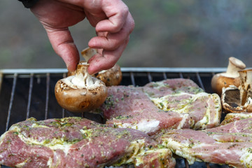 The process of cooking barbecue steaks on an open fire.