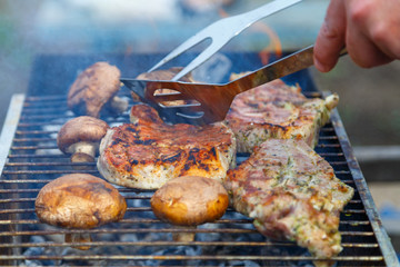 The process of cooking barbecue steaks on an open fire.
