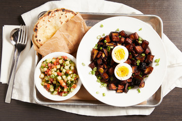 A delicious vegetarian dish featuring eggplant, tabouli and pita