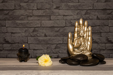 Statue de Bouddha sur fond de mur de pierres.	