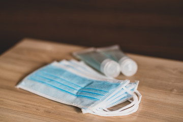 Hand sanitizer gel Anti virus protection and medical surgical masks with standard to prevent coronavirus COVID-19 infection.Medical protective on wood background.Healthcare and medical concept.