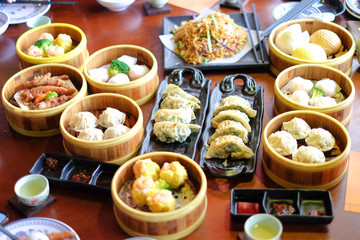Mixed chinese steamed dumpling (dim sum), crab stick, ha gow, seaweed, coriander, noodle, gyoza and garlic for background or texture - food chinese concept. © boyisteady