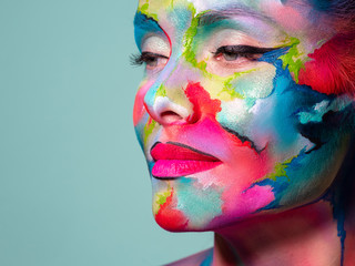 Face art and body art. Creative makeup with colorful patterns on the face. Modern makeup art, bold style,