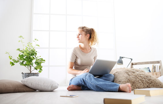young woman sitting in living room at the computer, stay at home concept
