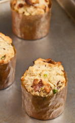 Top view, close up of a sweet corn and jalapeño muffin, in paper form, cooling on a metal baking tray