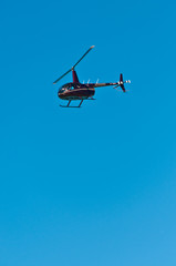 Fototapeta na wymiar Front, bottom view of a commercial, rental, helicopter in flight, over a sandy, tropical shoreline on gulf of mexico, on sunny, winter day