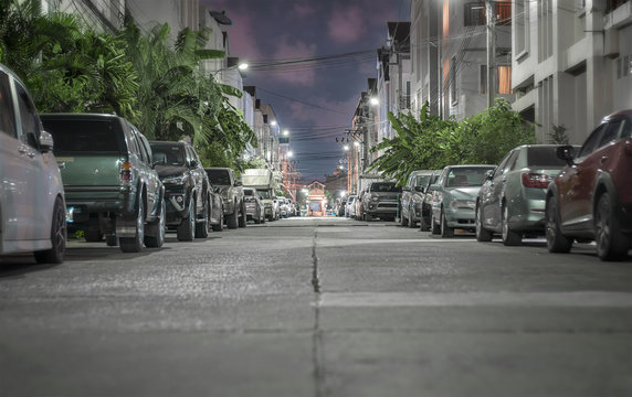 Cars Parked Along the Road During Twilight Hours in Residential Area in Thailand