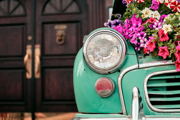 Mint british retro car with flowers on the background of the doors