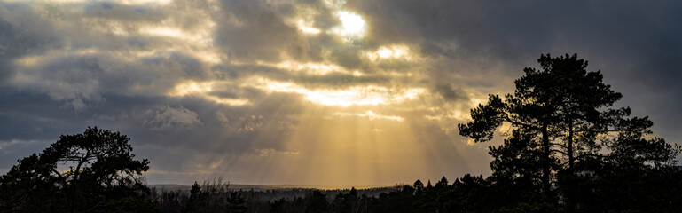 Obraz na płótnie Canvas The sun's rays shine through the clouds. Cloudy skies. Sunset landscape.