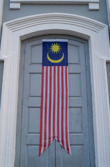 Fototapeta premium Malaysia flag banner at door of building.