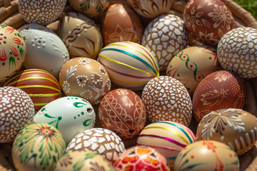 Full background of colorful, hand painted Easter eggs. Easter eggs in a wooden basket.Spring decoration. Painted Easter eggs.Festive tradition.Selective focus.Handmade Easter eggs