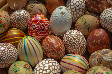 Full background of colorful, hand painted Easter eggs. Easter eggs in a wooden basket.Spring decoration. Painted Easter eggs.Festive tradition.Selective focus.Handmade Easter eggs
