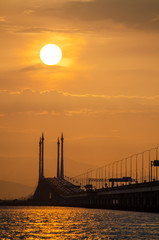 Obraz premium Silhouette sun at the top of mid span cable stayed bridge.