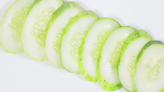 Sliced fresh green cucumber spinning on table