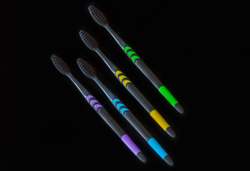 set of multi-colored toothbrushes on a black background