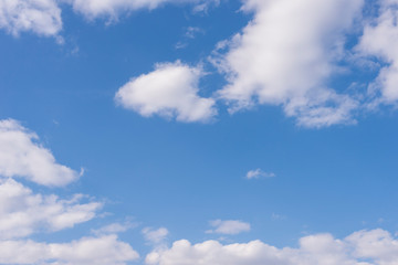 Spring blue sky with white clouds over the horizon on a sunny day background