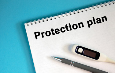 PROTECTION PLAN - text on a notepad. Lie a pen and a medical thermometer