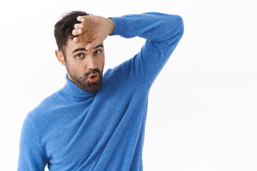 Phew that was close. Portrait of relieved handsome bearded man wiping sweat from forehead and...