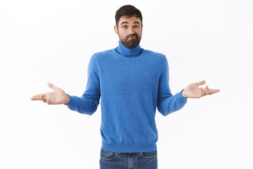 Portrait of unsure, perplexed bearded man in turtleneck, smirk indecisive, shrugging and spread hands sideways, dont know what do, have no idea, standing clueless and puzzled white background