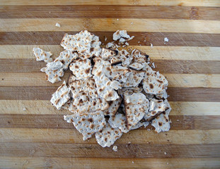 Crumbs of matzah on a wooden surface. Matzah - traditional Jewish food for Passover.