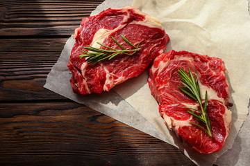 Fresh beef steaks on wooden table