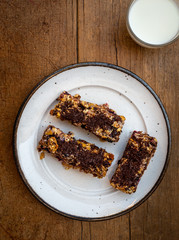 home made healthy cereal bars.in kitchen with glass of milk  honey pot ,& drizzler,