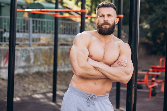 Handsome bearded bodybuilder man with perfect muscular body posing  outdoors. Strong man with naked torso standing, looking away. foto de Stock  | Adobe Stock