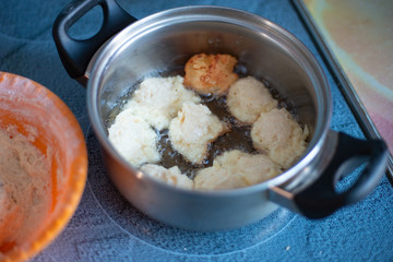 homemade cakes in a pan, fry sweet cheesecakes for tea, boiling oil