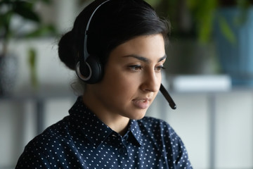 Head shot close up view young serious focused smart attractive indian ethnicity woman wearing...