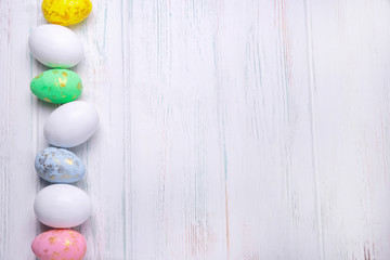 Frame for text with easter eggs on a light wooden background. Easter background with place for text. View from above