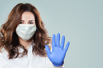 Happy smart doctor woman in a medical face mask showing stop pandemic gesture. Woman in safety mask and medical gloves. Flu epidemic and virus covid-19 protection concept