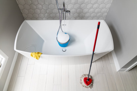 Directly above view of bathtub, mop and bucket to clean master bathroom